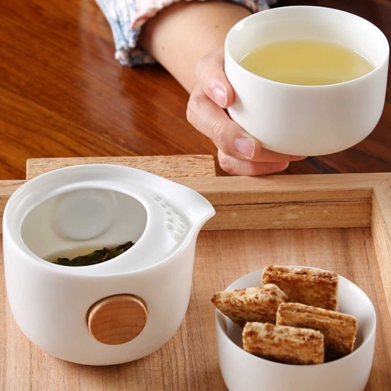 A person holding a cup with brew and On The Go Portable Gaiwan